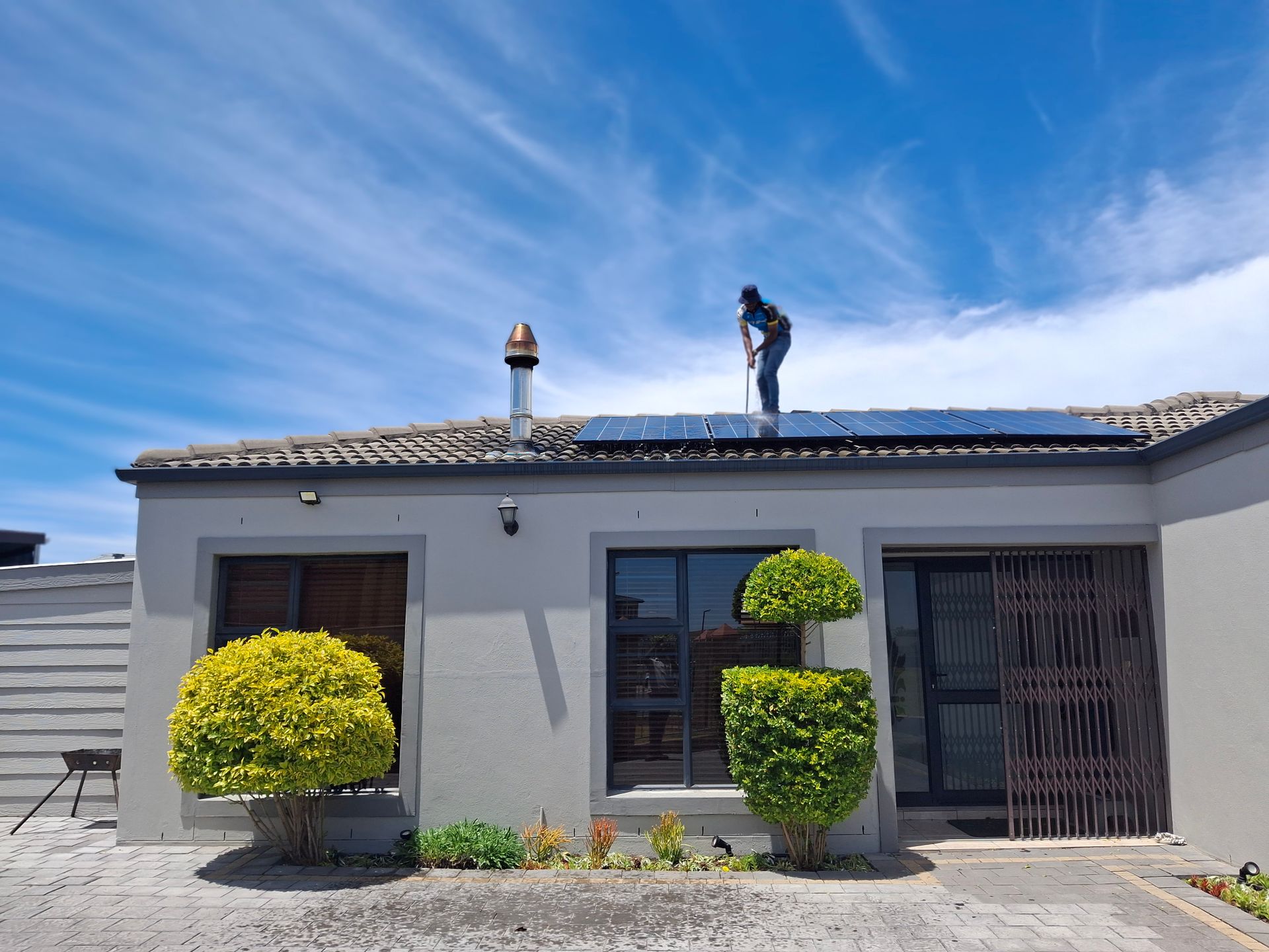 Monteur installiert Solarmodule auf einem Wohnhausdach